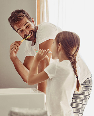 father and daughter brushing teeth