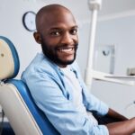 man in dental chair to get preventive care covered by dental insurance