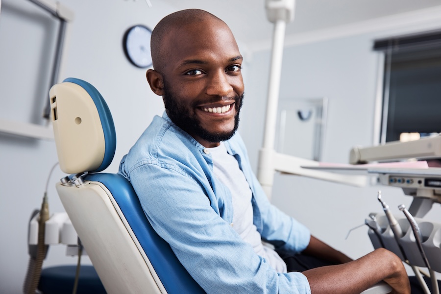 man in dental chair to get preventive care covered by dental insurance